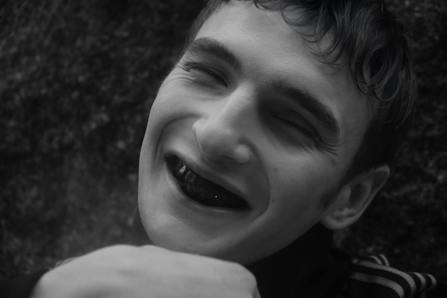 Smiling figure in a black sports jacket outdoors