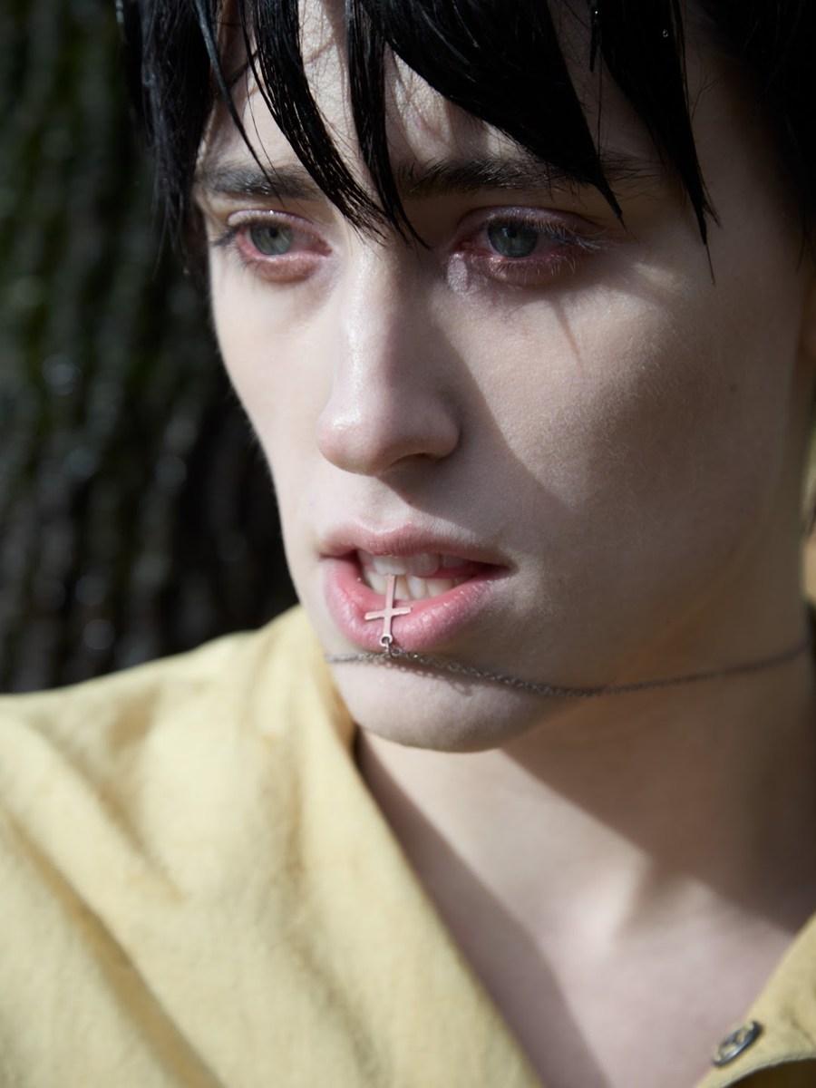 Colour portrait in a pale yellow shirt beside a tree
