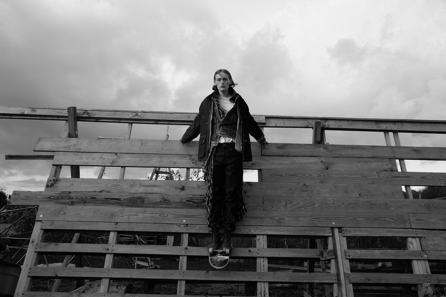 Black-and-white photograph of a figure on wooden stands beneath a cloudy sky