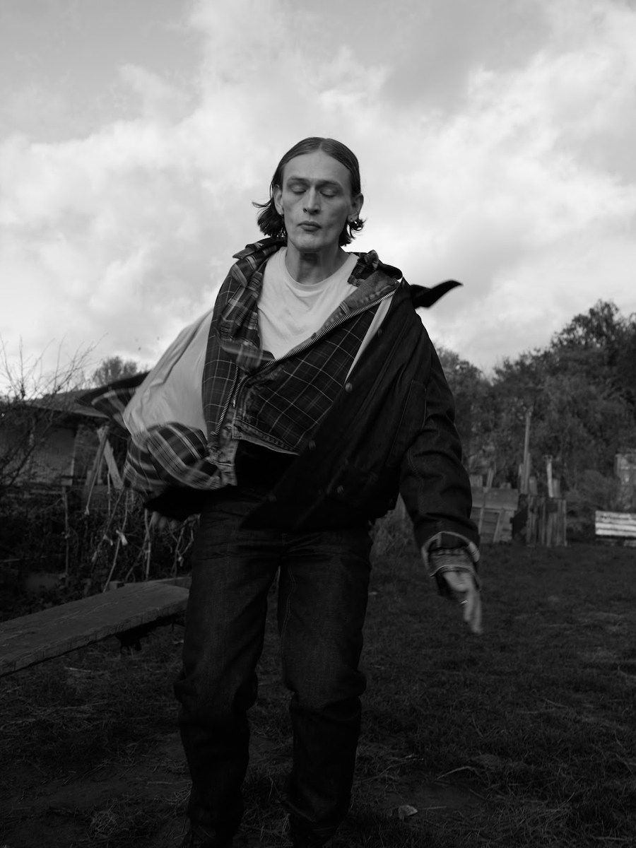 Figure in dark clothing with an open jacket outdoors
