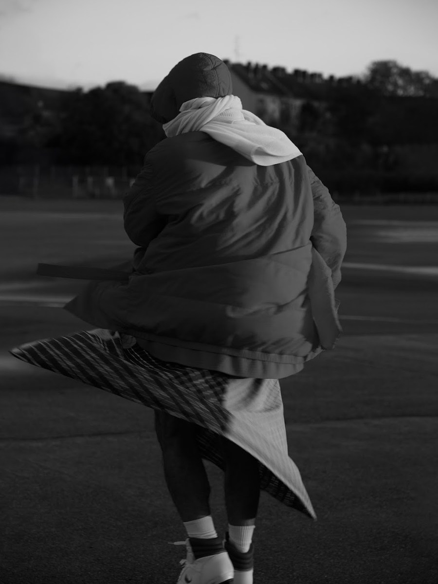 Figure seen from behind in a hooded padded jacket