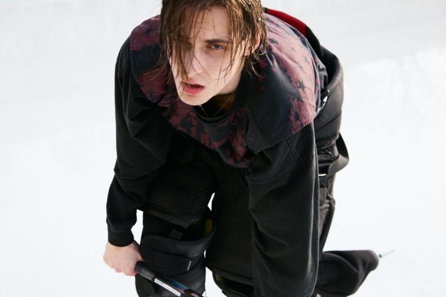 Marks leaning towards the camera on the ice in black hockey equipment