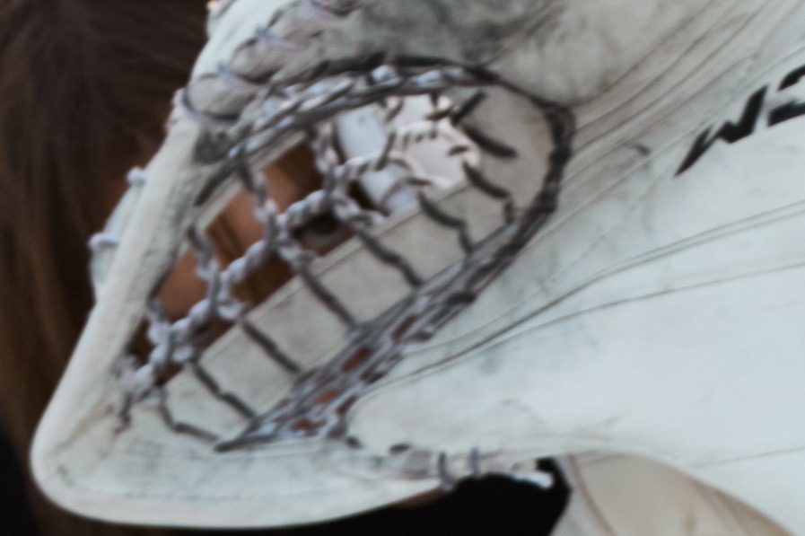 Marks looking through the lacing of a white goalkeeper glove